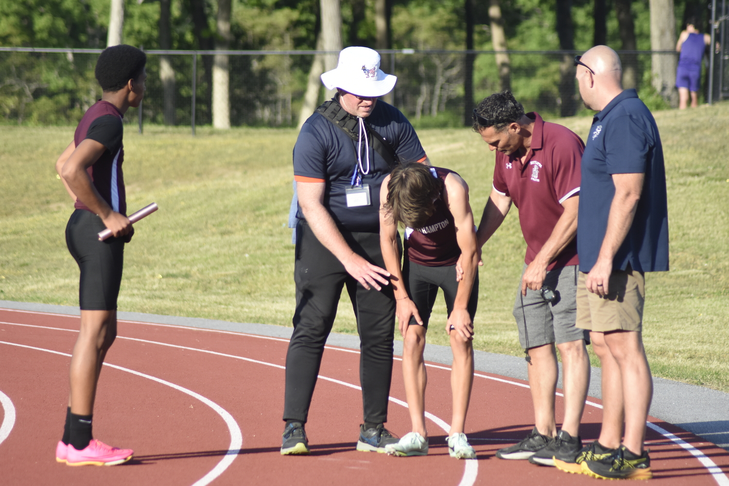 A trainer and coach Eddie Arnold help Tanner Marro to his feet after a hip injury caused him to go down.    DREW BUDD