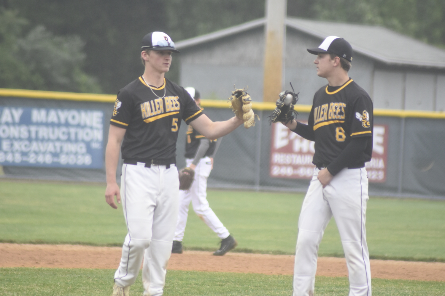 Fellow senior Dylan Fitzgerald gives some words of encouragement to his pitcher Scott Vinski just prior to the start of an inning.   DREW BUDD