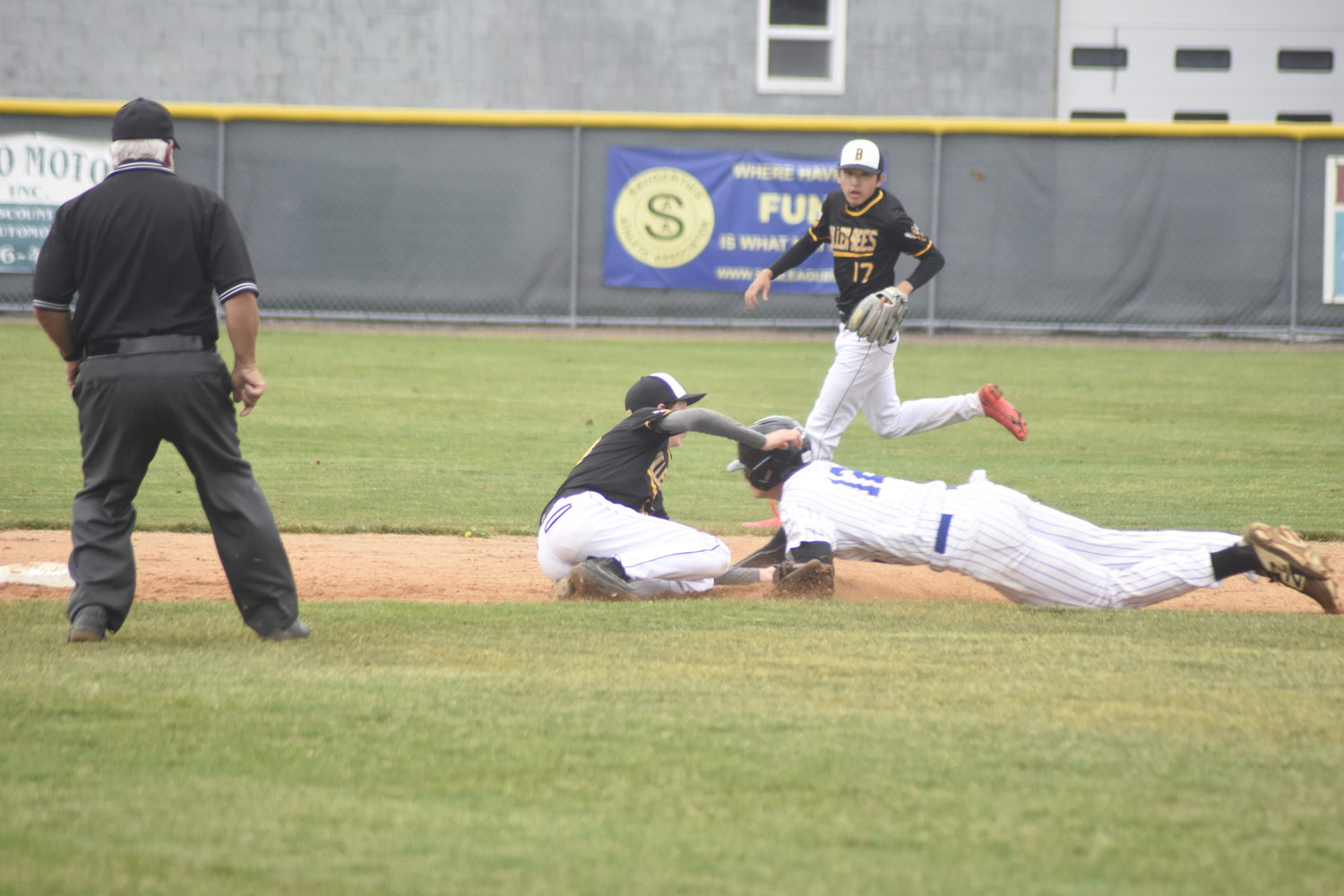 Ross freshman shortstop Tate Foard tags out Chapel Field's Logan Garvey trying to steal second base.   DREW BUDD