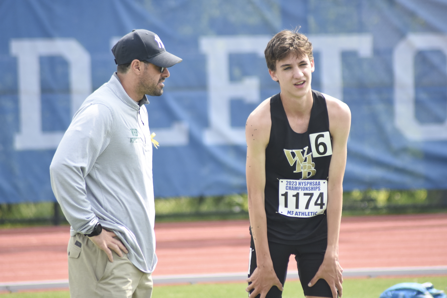 Westhampton Beach head coach Joe Mensch checks out Trevor Hayes after he pulled himself out of his race.   DREW BUDD