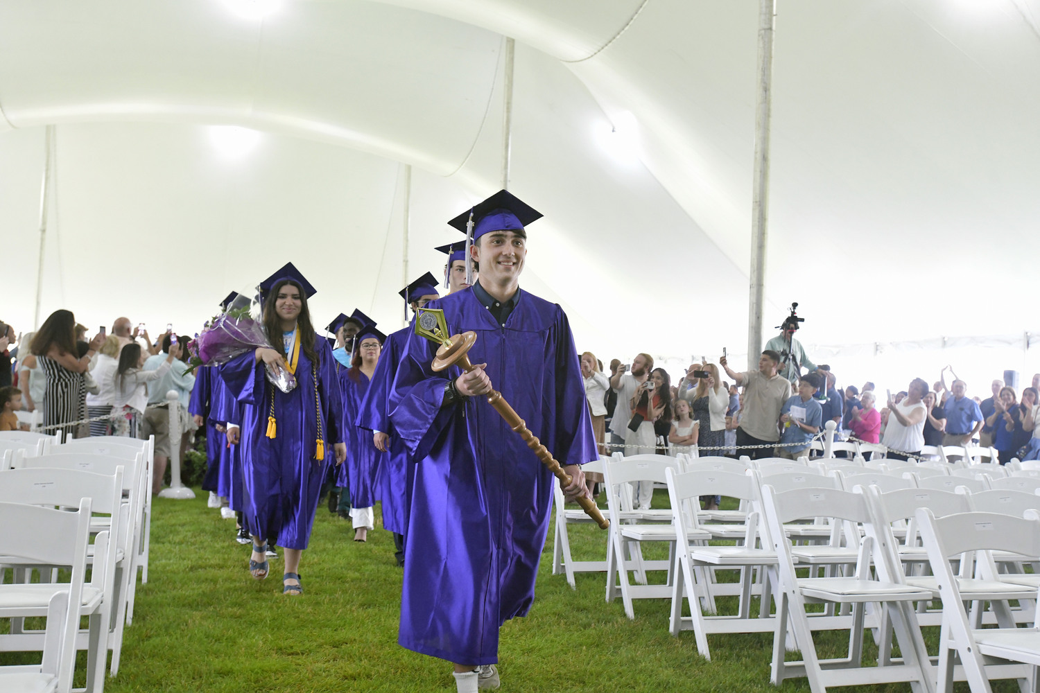 Graduates enter the tent during Hampton Bays commencement exercises on Saturday.  DANA SHAW