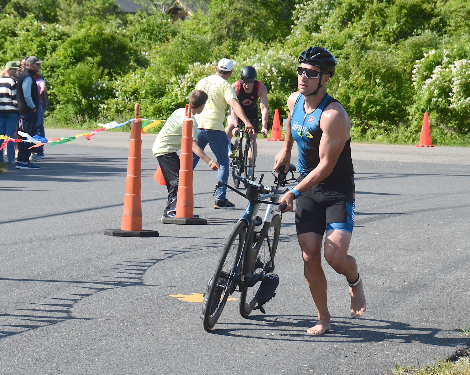 Triathletes make the transition from the bike to the run portion.   KYRIL BROMLEY