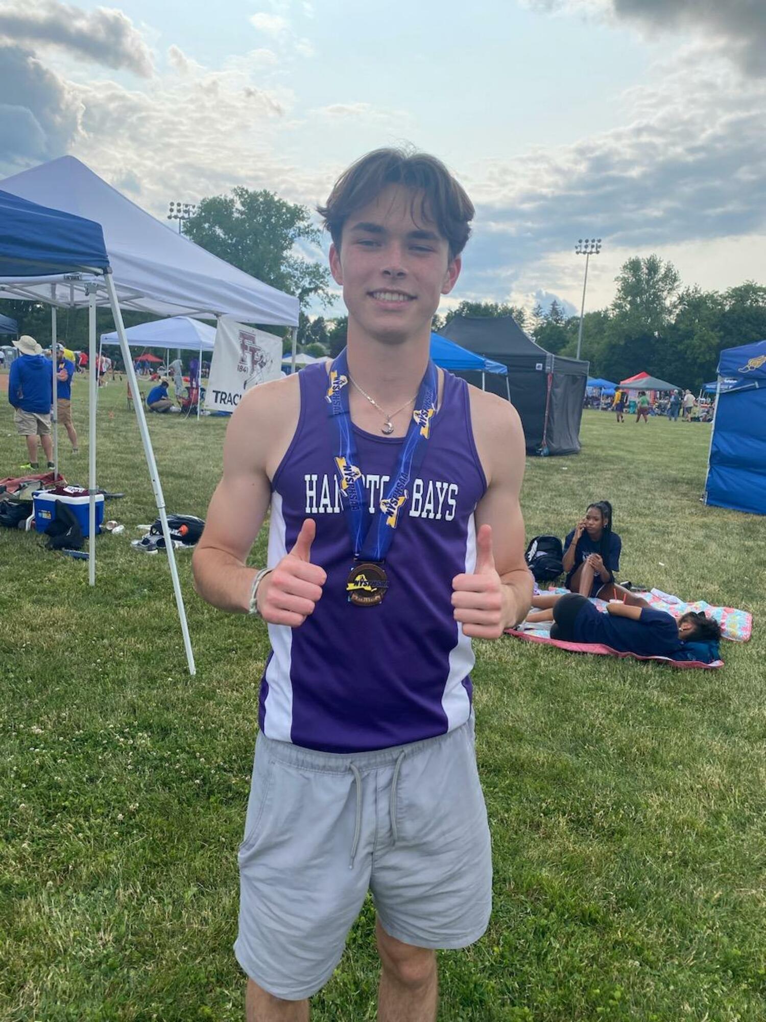 Hampton Bays senior Liam Sutton with his medal he earned in the 400-meter intermediate hurdles.