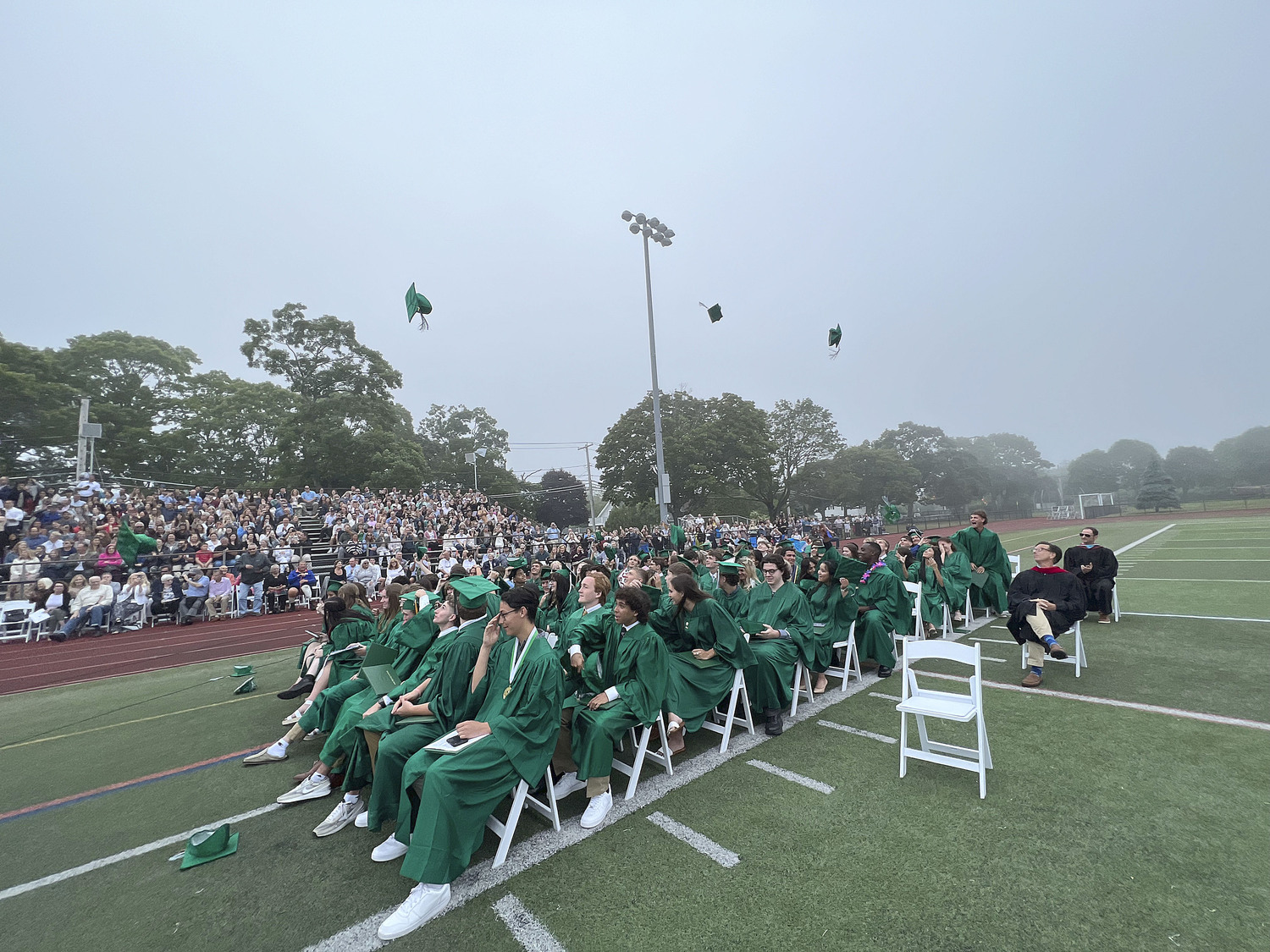 Graduates at Westhampton Beach High School toss their caps after graduating on Friday evening.  DANA SHAW