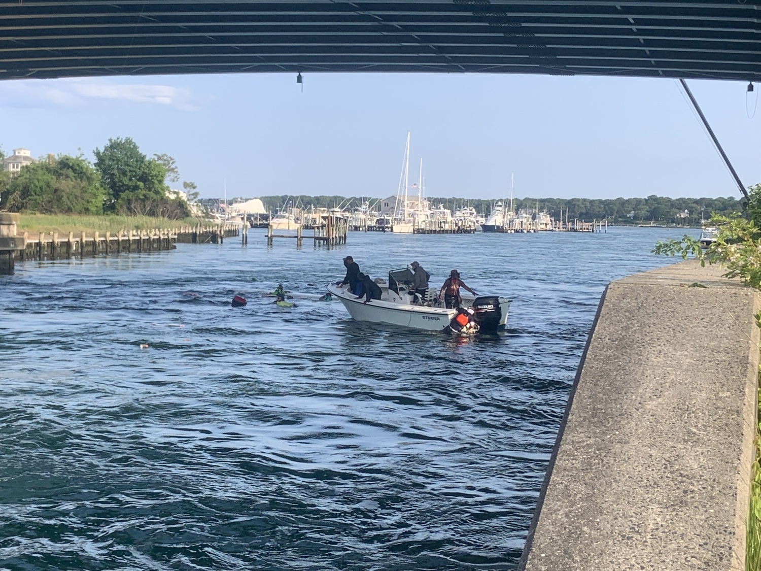 The chase boat helps the team of six who were arriving in the Shinnecock Inlet during a multiday  canoe journey from Boston to New York City. STEPHEN J. KOTZ