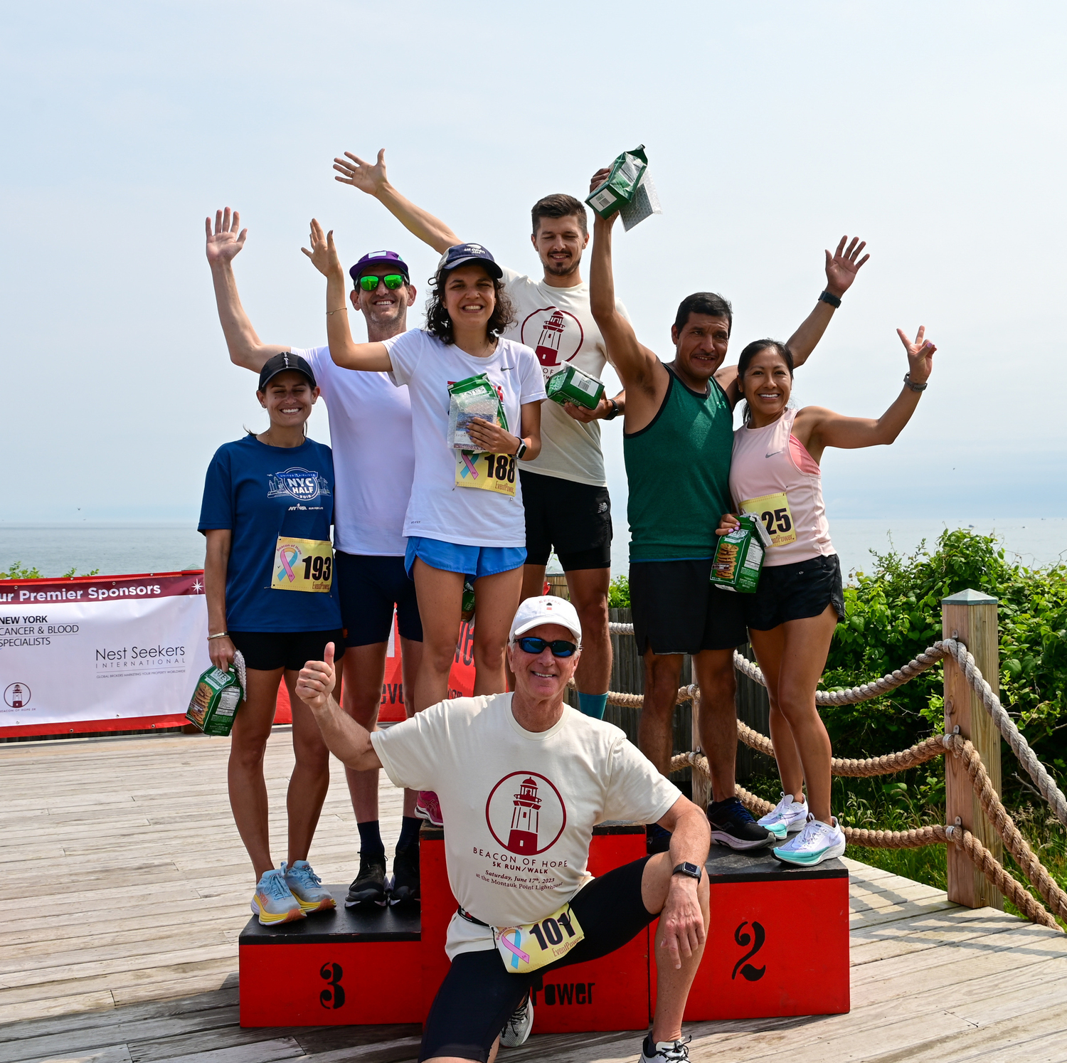 The top three finishers in both the mens and womens races take to the podium along with Montauk Lighthouse keeper Joe Gaviola.    ED GRENZIG/LONG ISLAND RUNNING