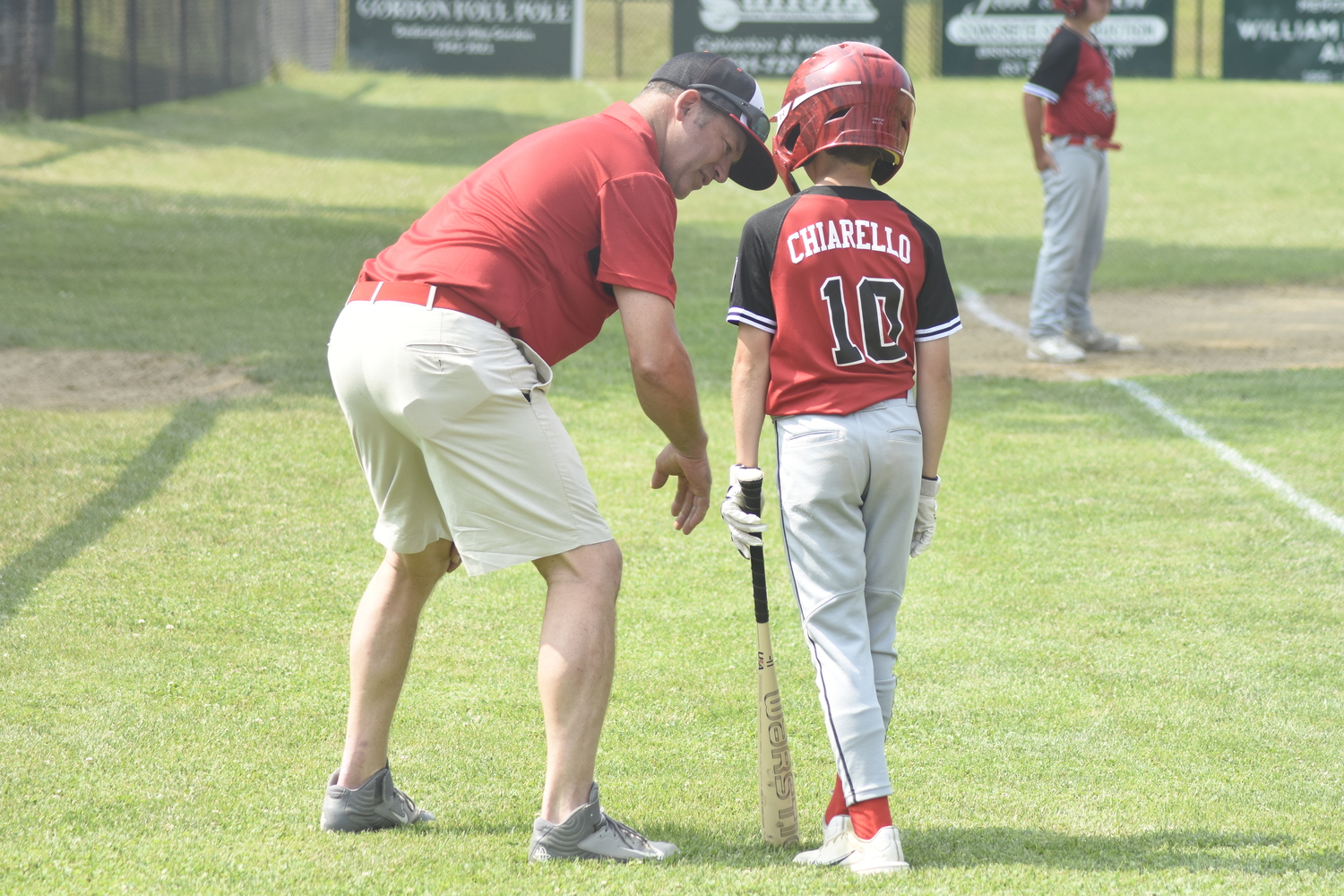 Sag Harbor 10U baseball All-Stars assistant coach Ike Birdsall has a few pointers for Van Chiarello.   DREW BUDD