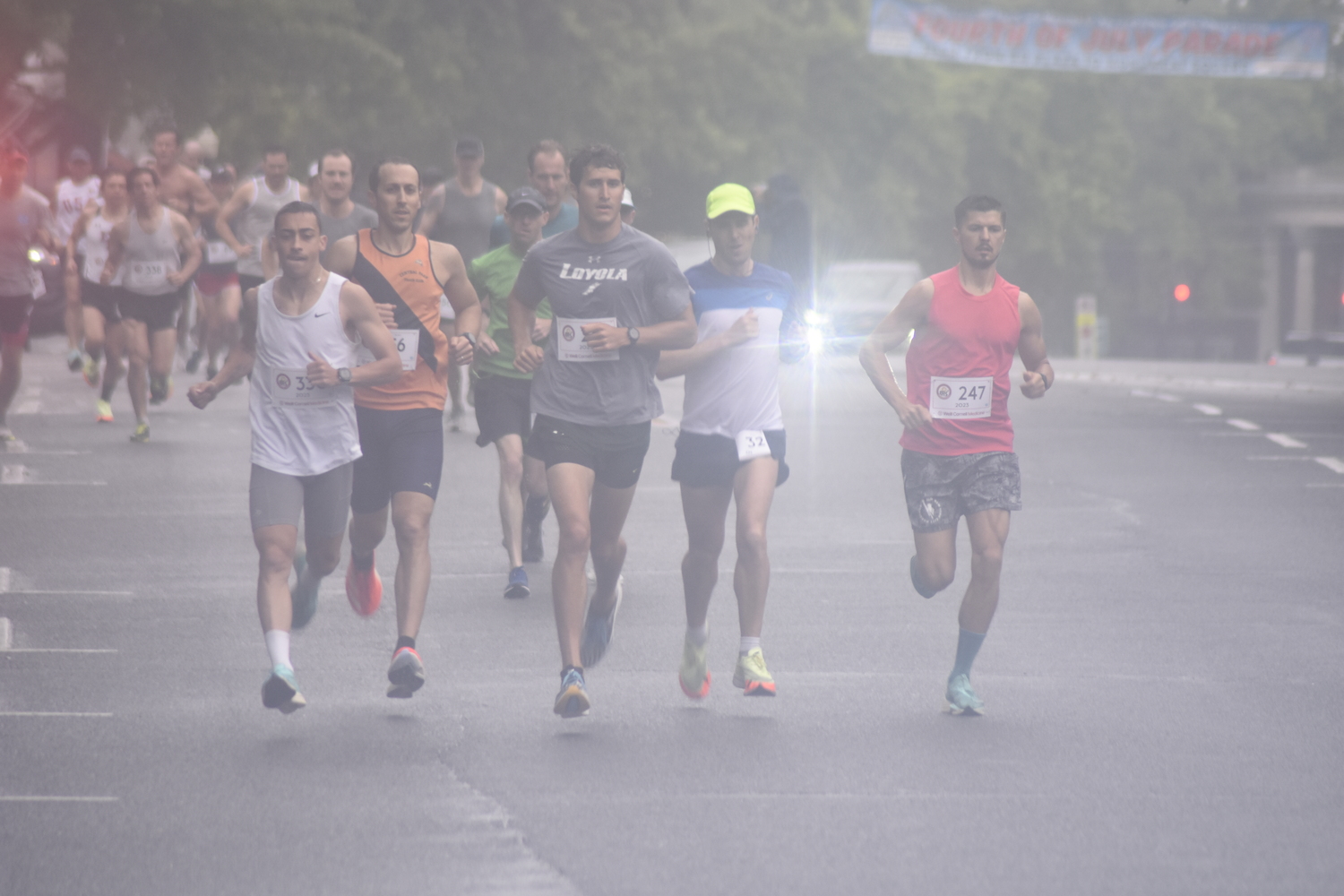 Runners make the first turn off Jobs Lane onto South Main Street at the start of the 32nd annual Firecracker 8K in Southampton on Sunday morning.   DREW BUDD