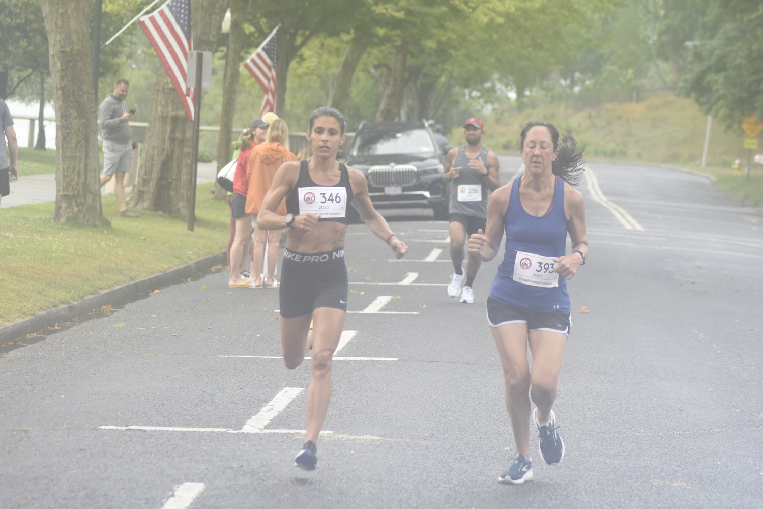 Friends Tara Farrell, left, and Heather Wright cross the finish line together. They finished second and third, respectively, among women.   DREW BUDD