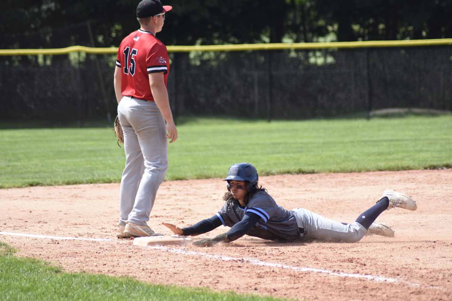 Whaler T.J. Werner (Farleigh Dickinson) slides head first into third base after tagging up from second on a deep fly ball to center field.    DREW BUDD
