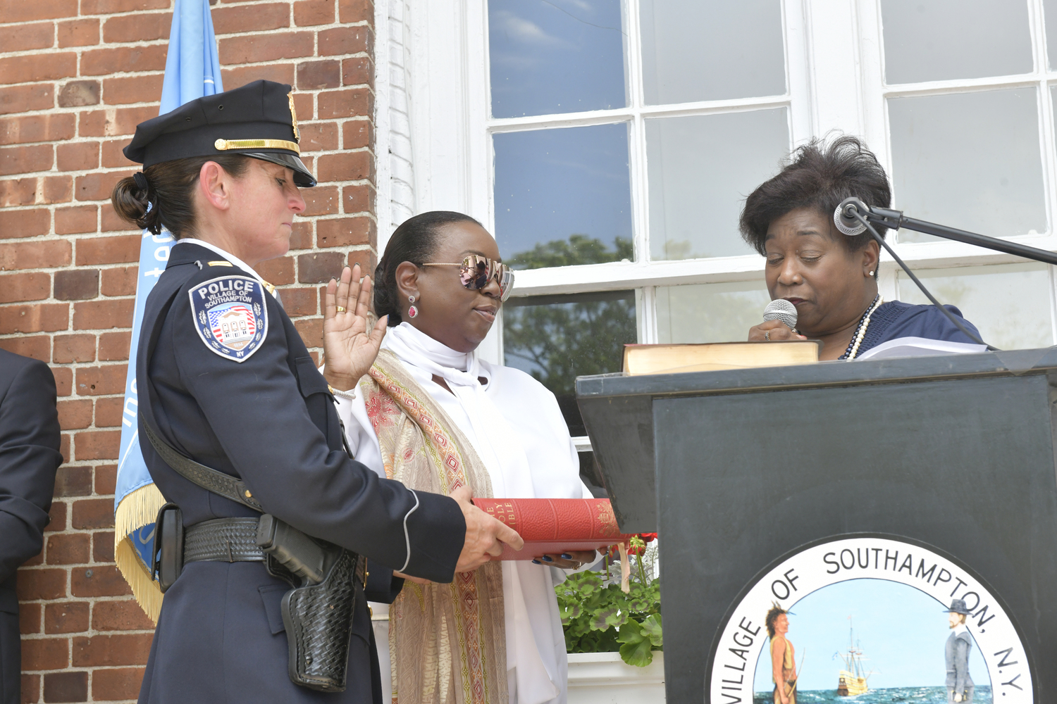 Southampton Village Trustee Robin Brown is sworn in by her cousin Judge Andrea Phoenix while newly appointed Chief of Police Suzanne Hurteau holds the Bible on Monday at Southampton Village Hall.   DANA SHAW