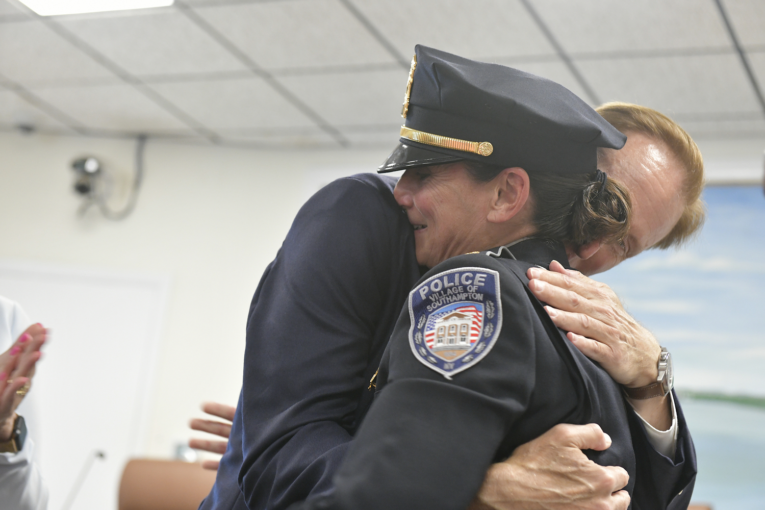 Captain Suzanne Hurteau hugs Mayor Bill Manger after being sworn in as the new Chief of Police of Southampton Village on Monday .  DANA SHAW