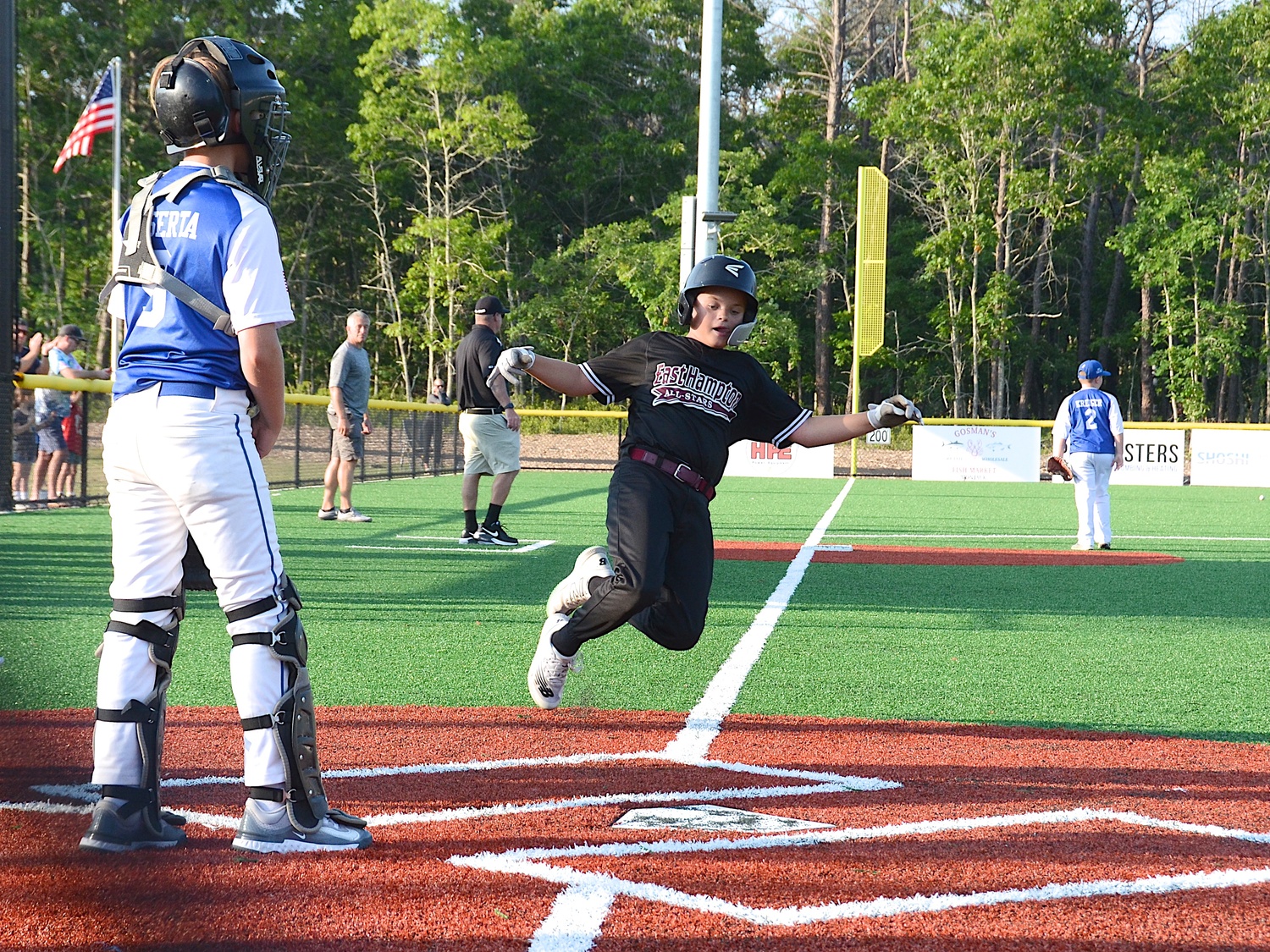 Griffin Page slides at home plate without a throw after the ball was thrown into the outfield.  KYRIL BROMLEY