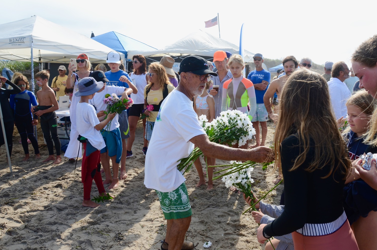 Roger Feit, co-founder and co-director, hands out flowers to those in attendance for 