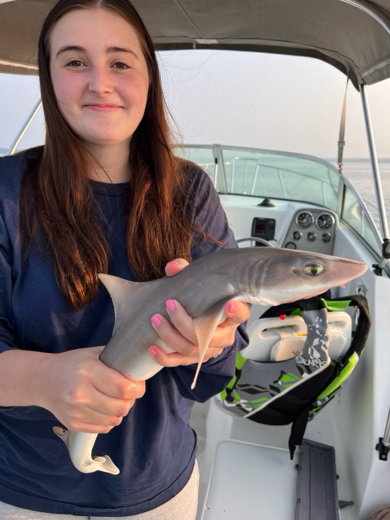 The author's granddaughter, Faith Daniels, with her catch of a weakfish and a sand shark.