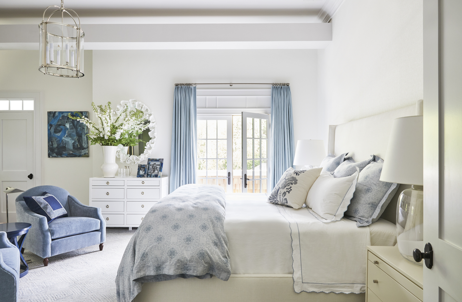 The primary bedroom also features a summery blue palette.   GENEVIEVE GARRUPPO