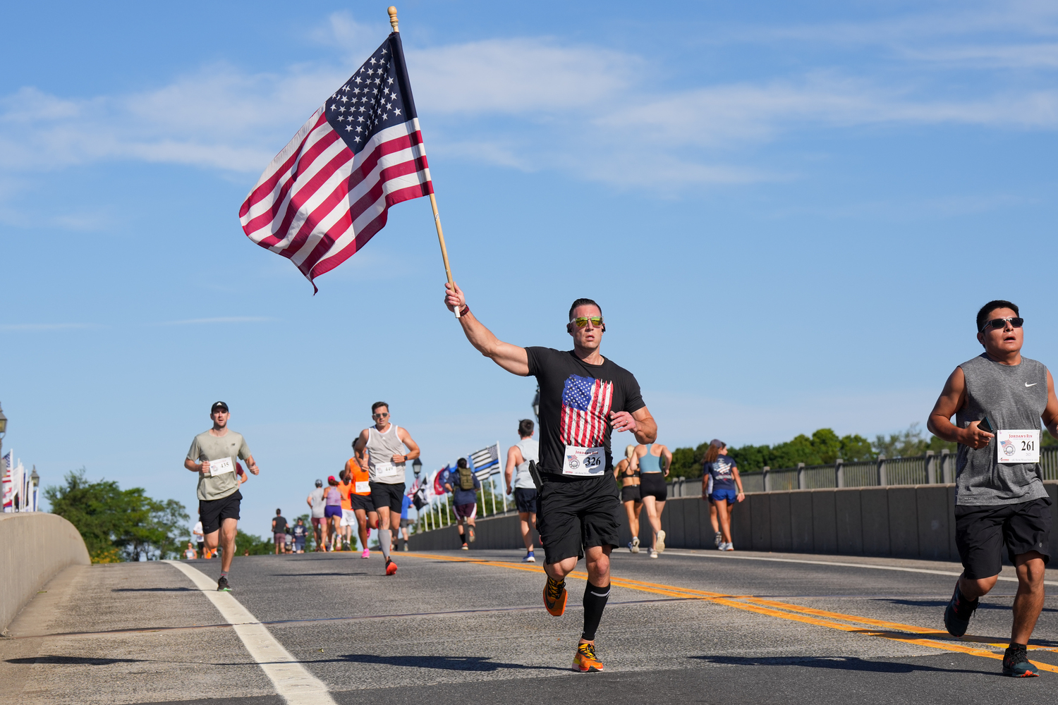 Gregory Waxman holds the flag high as he heads over the Lance Cpl. Jordan Haerter Veterans’ Memorial Bridge.   RON ESPOSITO