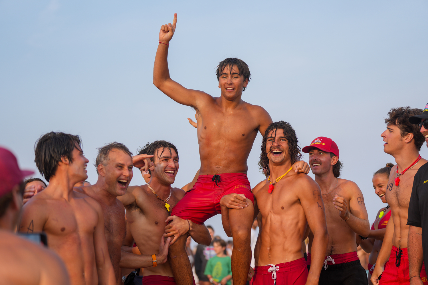 East Hampton Village Lifeguard J.P. Amaden gets hoisted up by fellow lifeguards Avery Sharen and Frankie Hammer after winning the paddle board relay. RON ESPOSITO