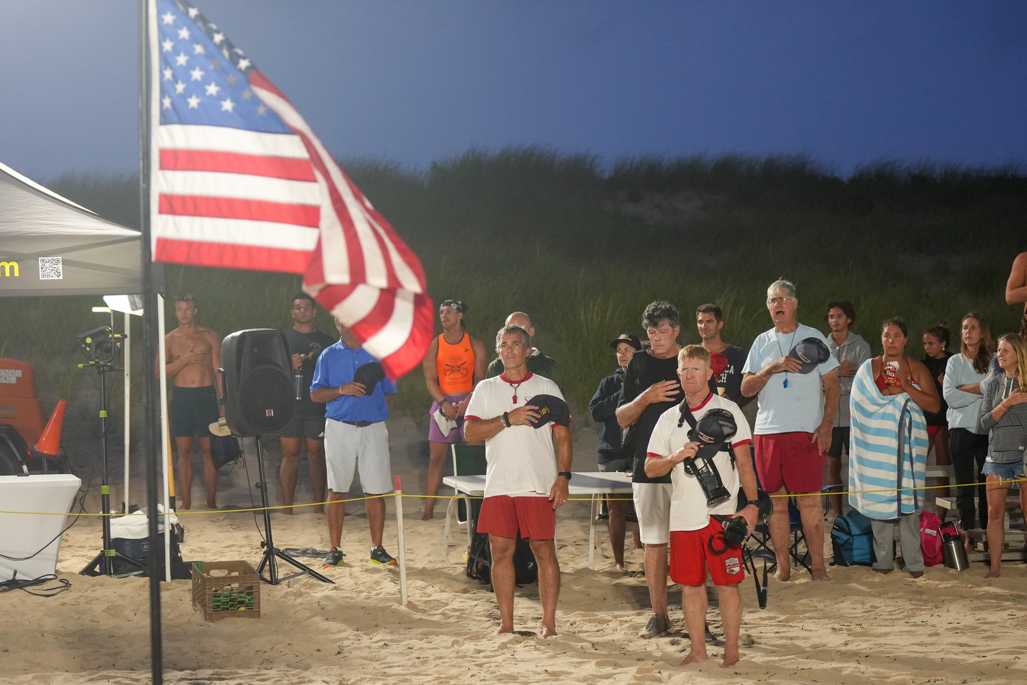 East Hampton Town Chief Lifeguard John Ryan Jr., bottom right, and others during the national anthem.   RON ESPOSITO