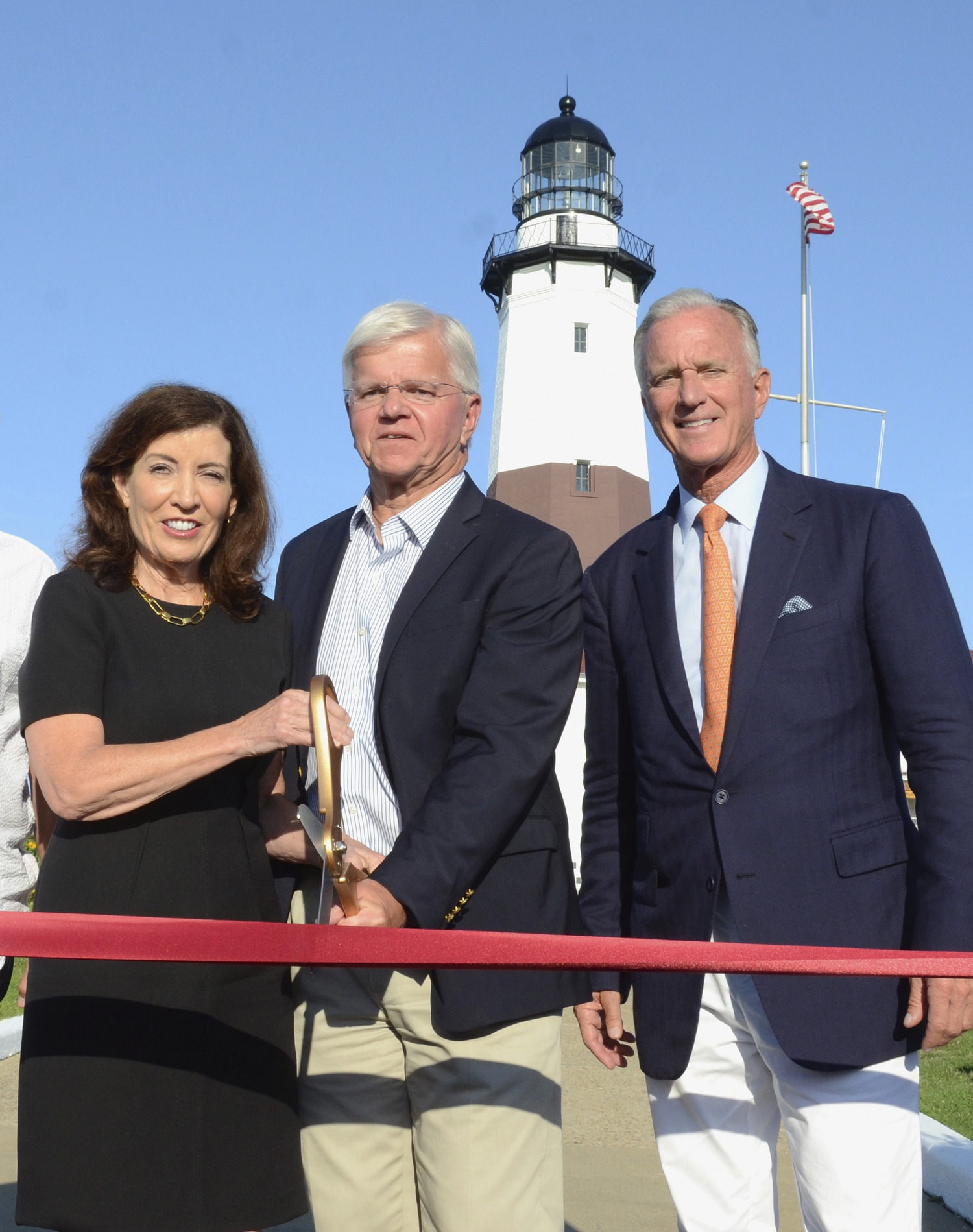 Governor Kathy Hochul, Assemblyman Fred W. Thiele Jr and Lighthouse Keeper Joe Gavioloa celebrating the completion of the restoration work at Montauk Point Lighthouse.    KYRIL BROMLEY