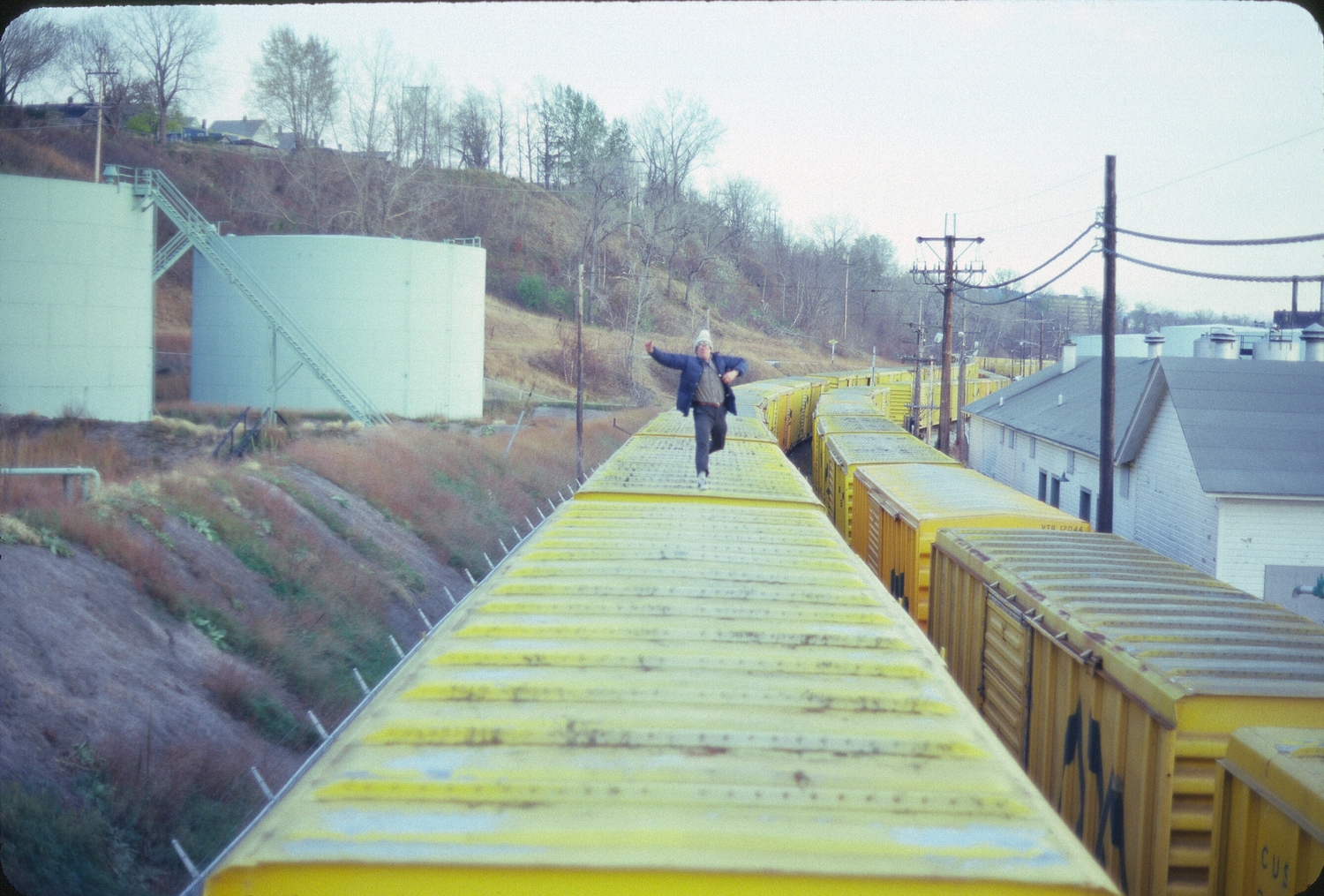 Doug Feiden runs across the top of a parked freight train in Burlington, Vermont, 1980. COURTESY WAYNE FEIDEN