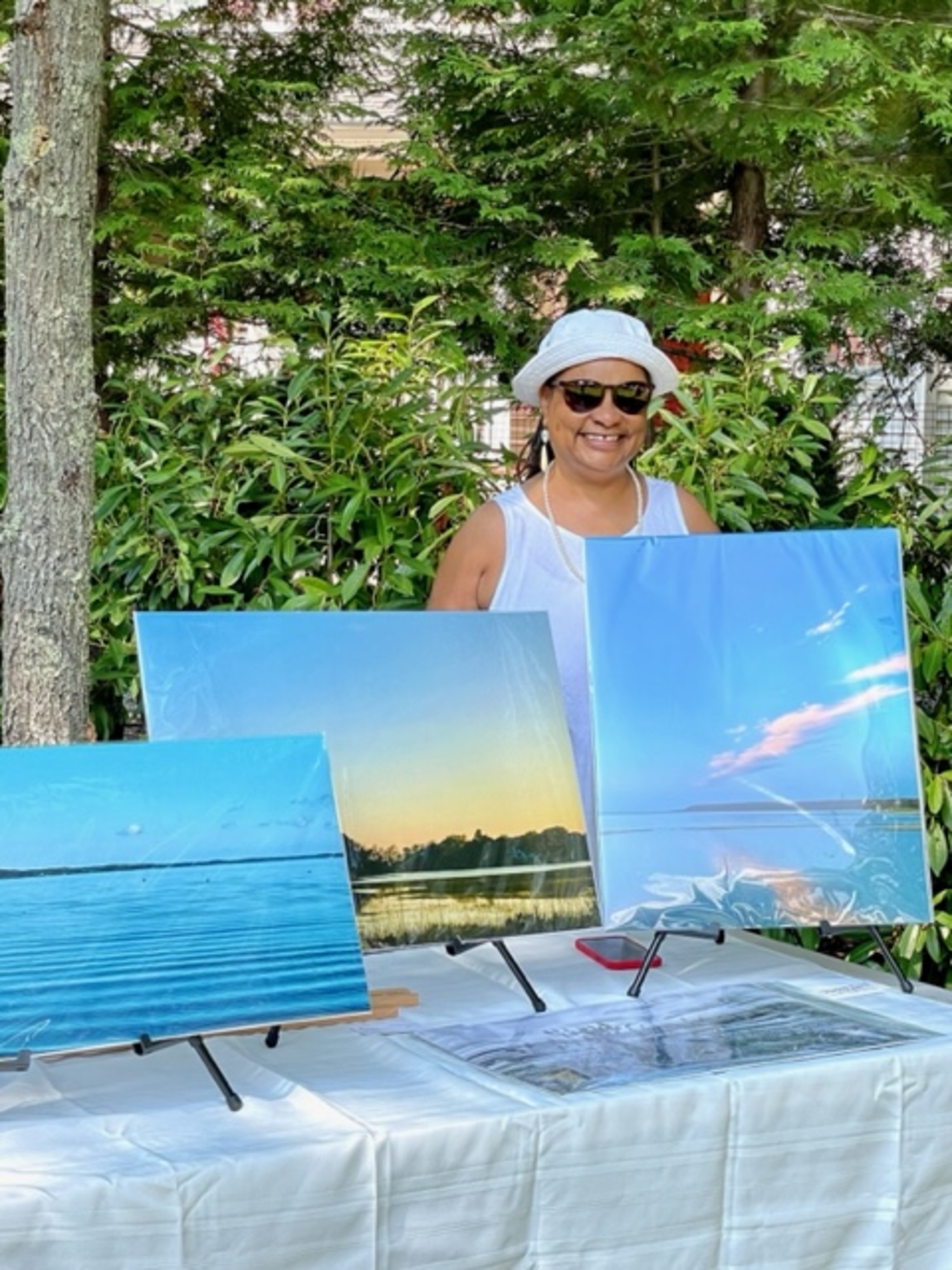 Photographer DonnaMarie Barnes with her work at the 2022 Celebrating Creatives of Color outdoor art sale. COURTESY CELEBRATING CREATIVES OF COLOR COMMITTEE
