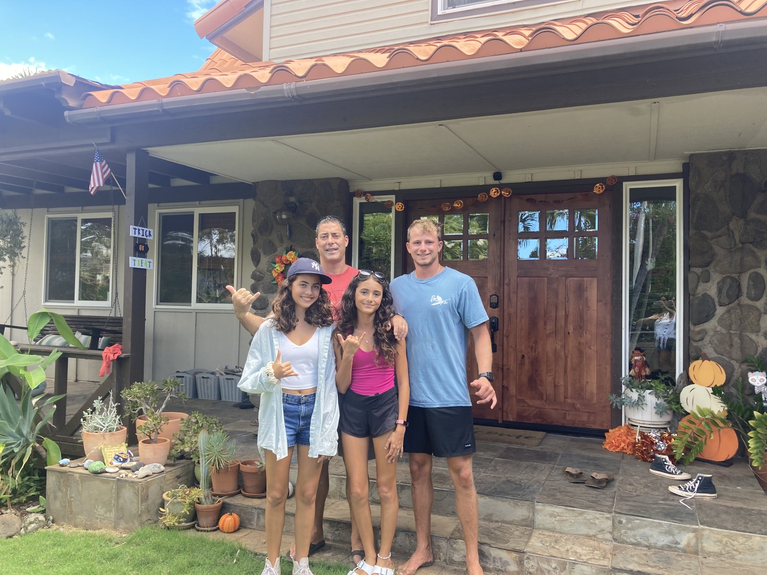 Keenan Reeder, left, with fellow Tiana Beach lifeguard Anthony Cappadano, as well as Reeder's daughters at their home in Lahaina on Maui. Their home was destroyed in the fires.