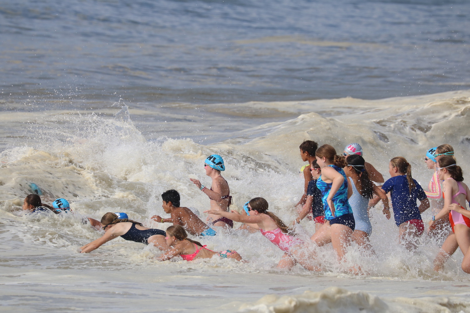 Junior lifeguards diving into the surf for the distance swim.  CINTIA PARSONS