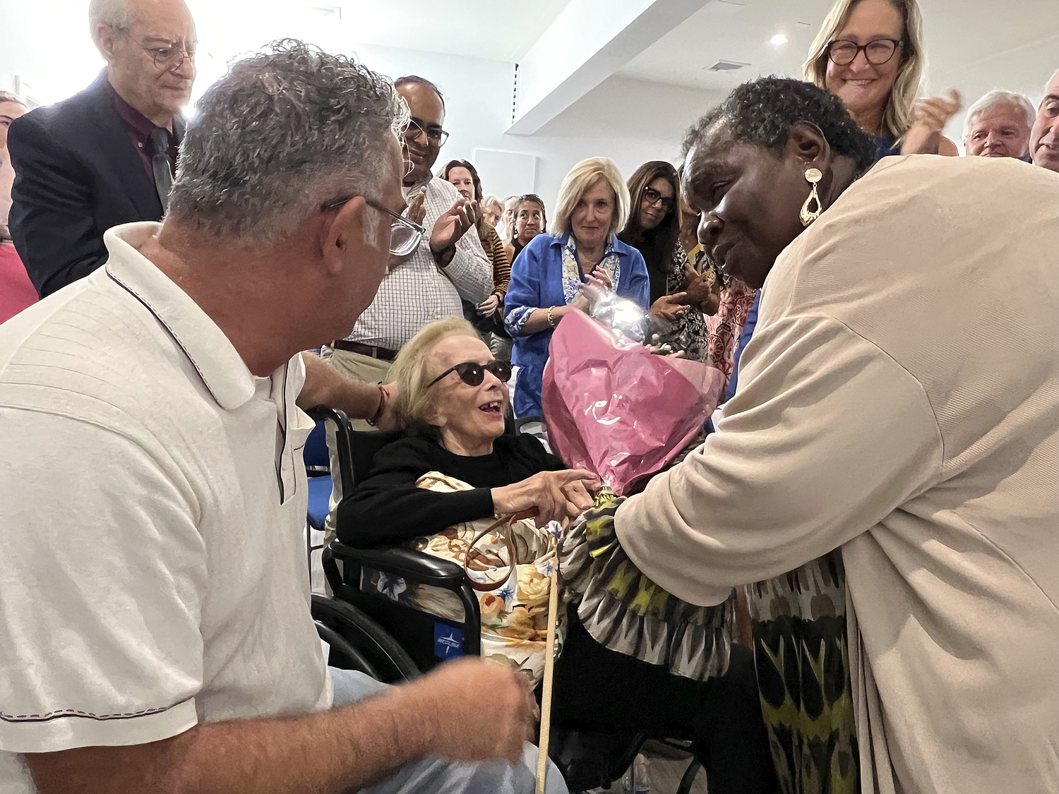 Bridgehampton Child Care and Recreational Center Executive Director Bonnie Michelle Cannon presents flowers to Barbara Slifka at the center on Friday.  DANA SHAW