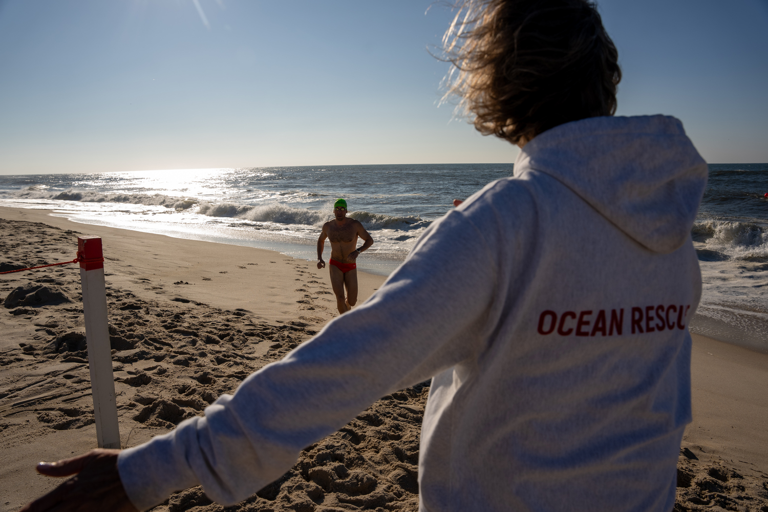 A swimmer gets out of the water and heads toward the finish line.   RON ESPOSITO