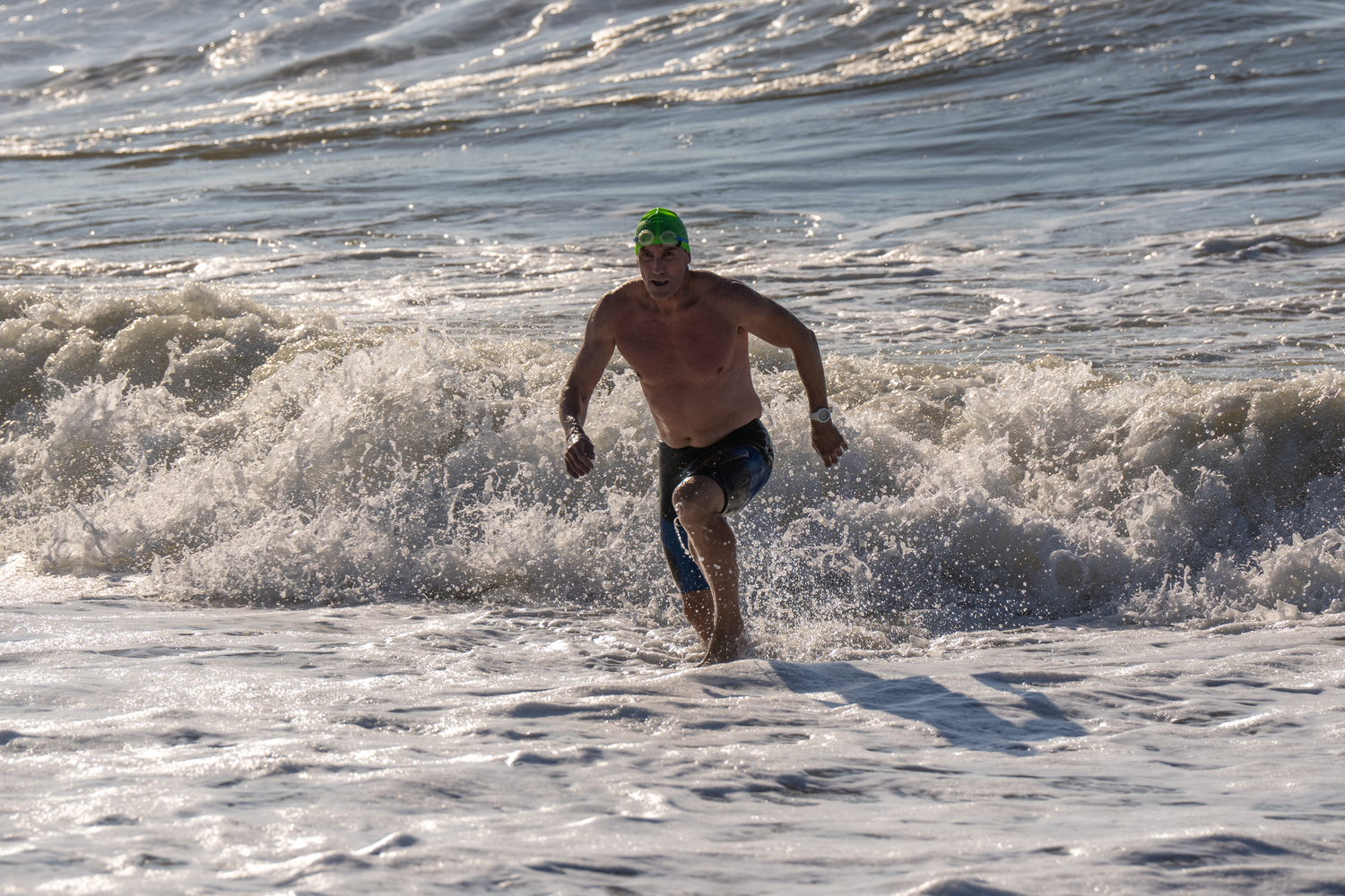 A swimmer gets out of the water and heads toward the finish line.   RON ESPOSITO