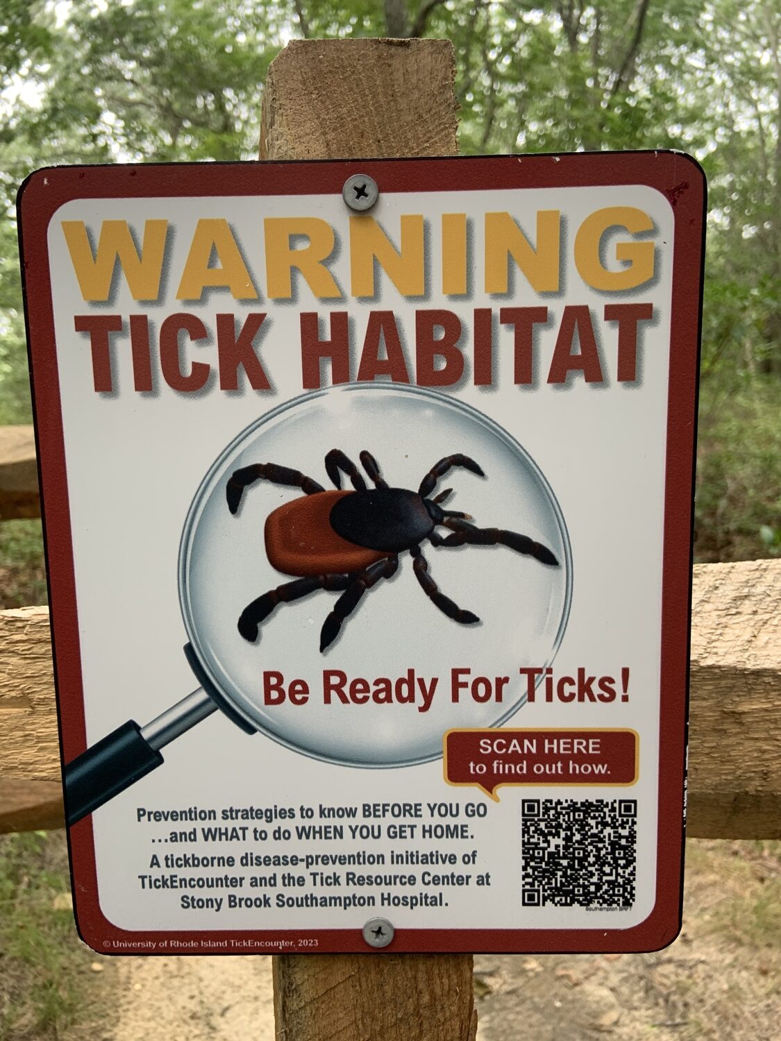 The placards include a QR code that links to information about staying safe from ticks while on the trails.
