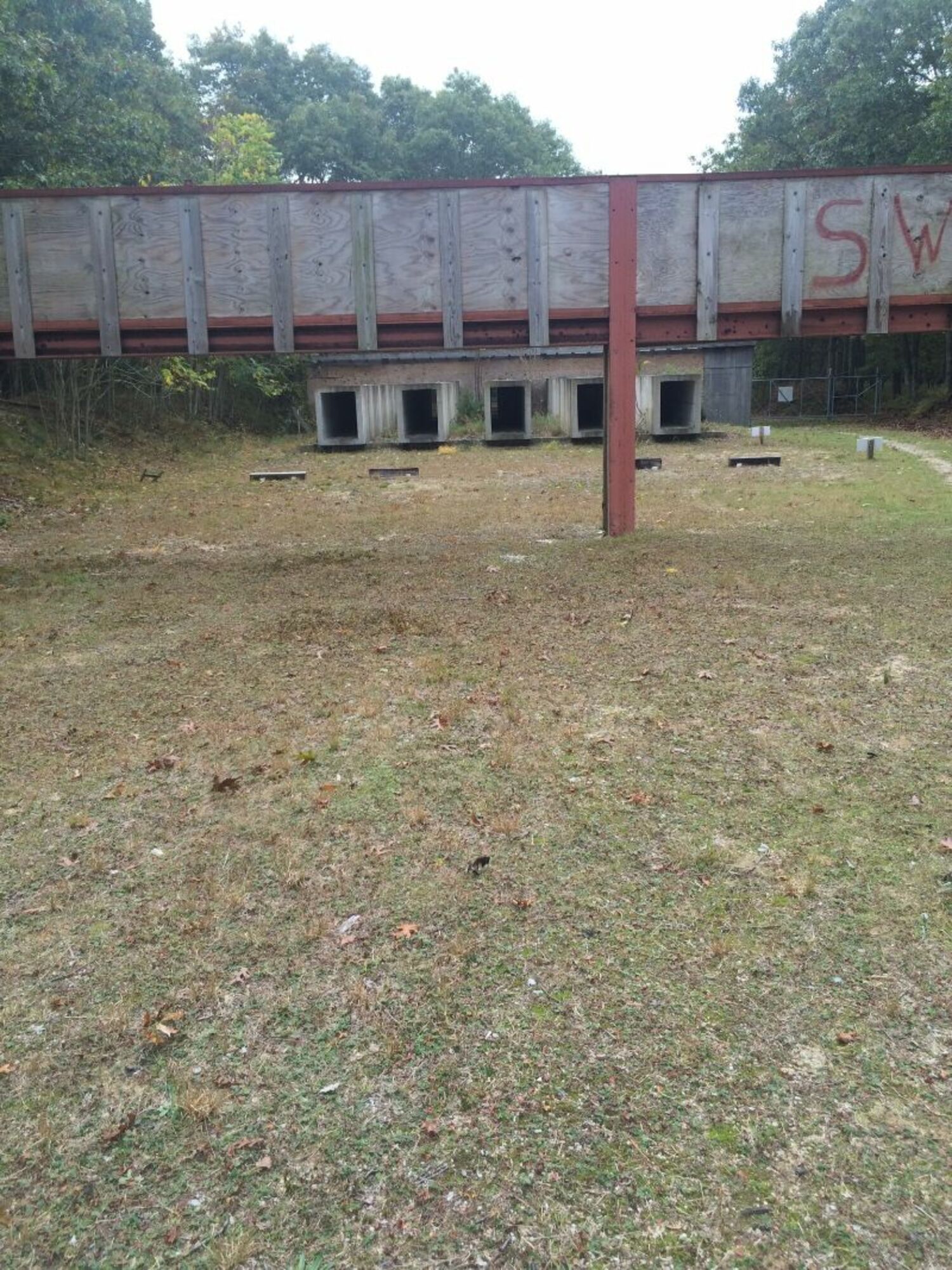 The current rifle range is open air and relies on concrete shooting tunnels and wooden barricades to contain bullets on the range.