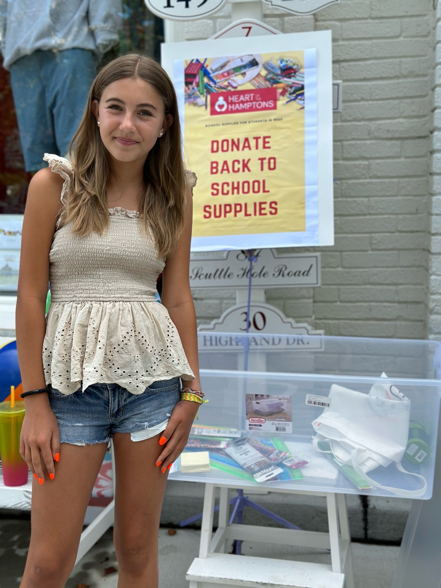 Westhampton Beach eighth-grader Leah Ravin collecting donations for Heart of the Hampton's Backpack Kids program outside of Quogue Shop on Tuesday. KARYN RAVIN