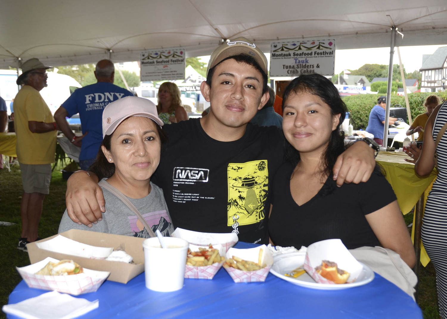 Fanny Mejia, Jonny Saltos and Valeria Macas at the Montauk Seafood Festival on Sunday to Benefit the Montauk Friends of Erin and the Kiwanis Club of East Hampton .  KYRIL BROMLEY