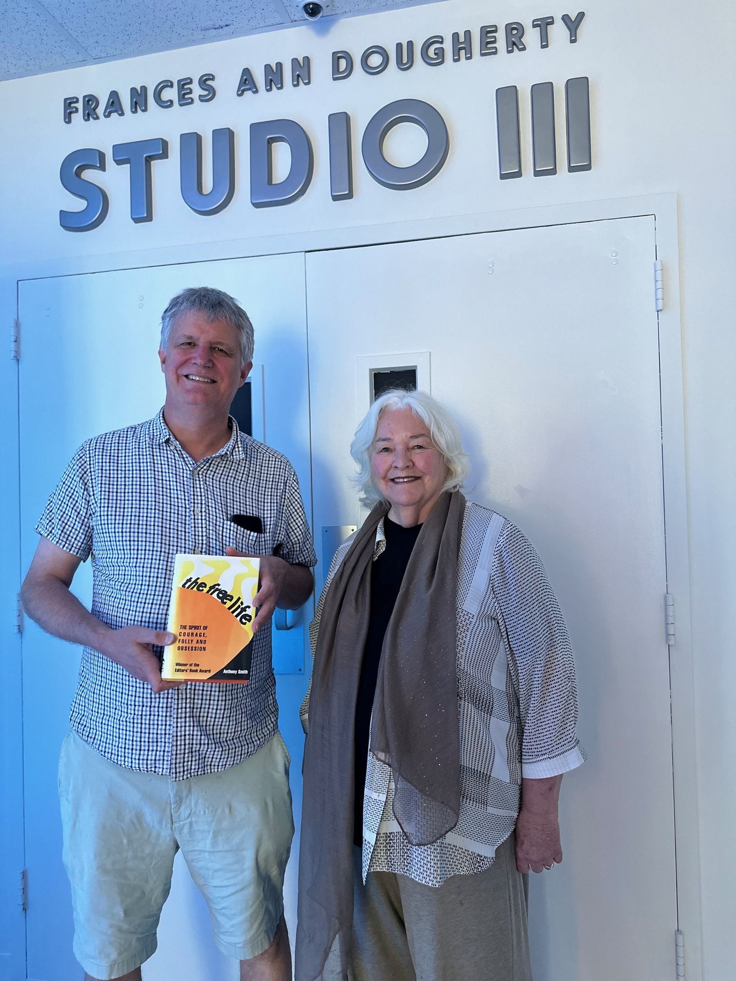 Musician and composer Dan Koontz with Genie Chipps Henderson. Koontz holds a copy of 