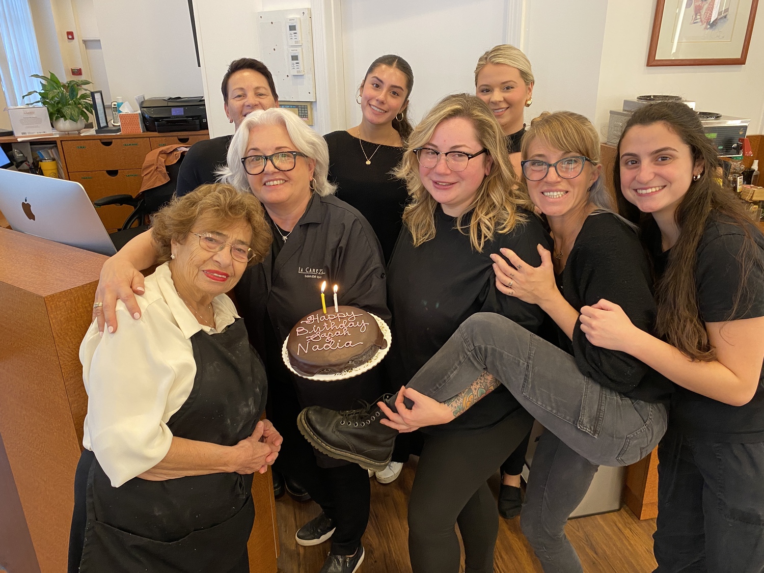 Staff at LaCarezza salon in Southampton gathered around Nadia Marshall, left, to celebrate her 93rd birthday last Saturday. Marshall has been an aesthetician at the salon for 32 years. Holding the cake is salon owner Deb Cirruzzo. KIM COVELL