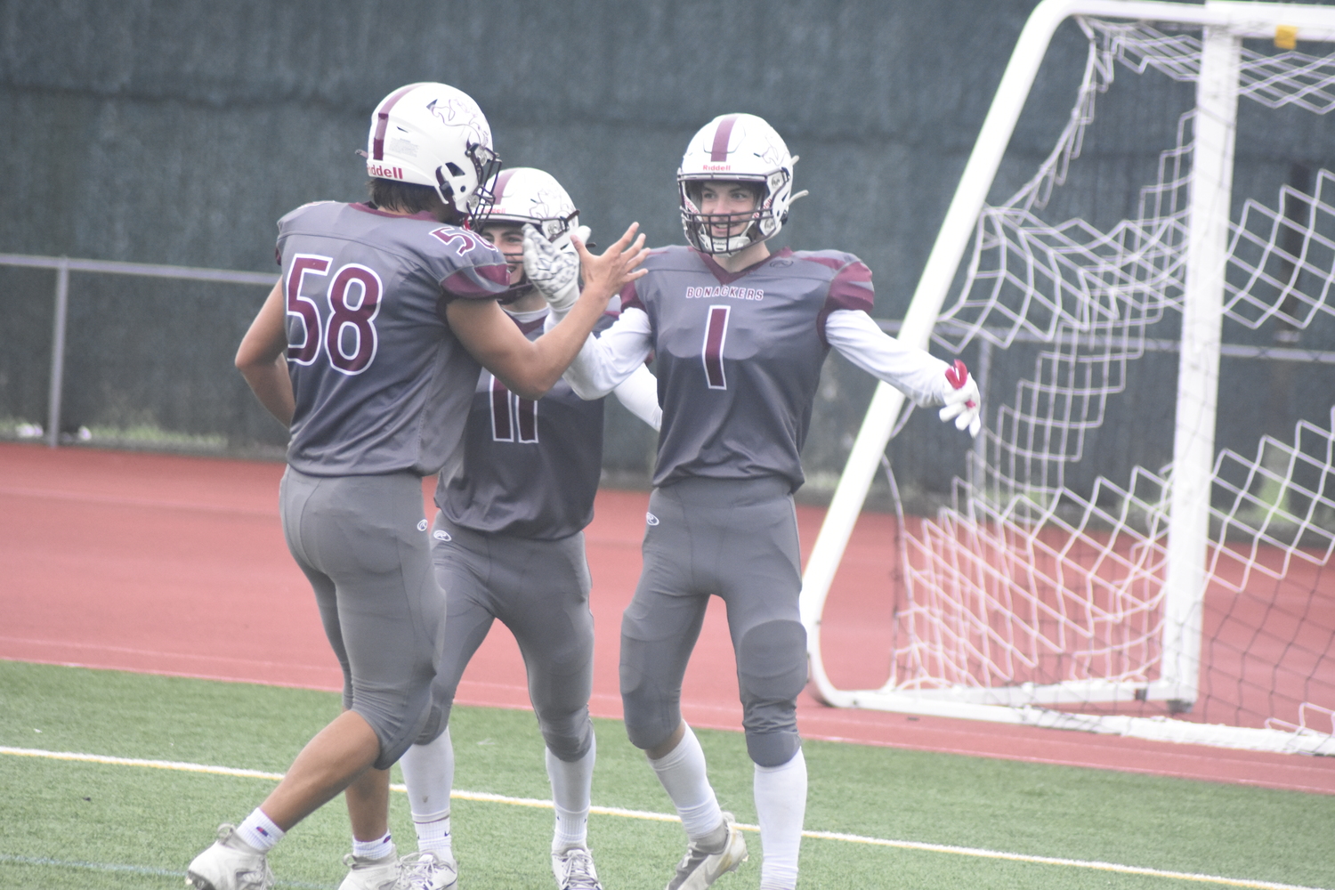 Jason Lester is congratulated by teammates Henry Butler and Thinley Edwards after scoring a touchdown.   DREW BUDD
