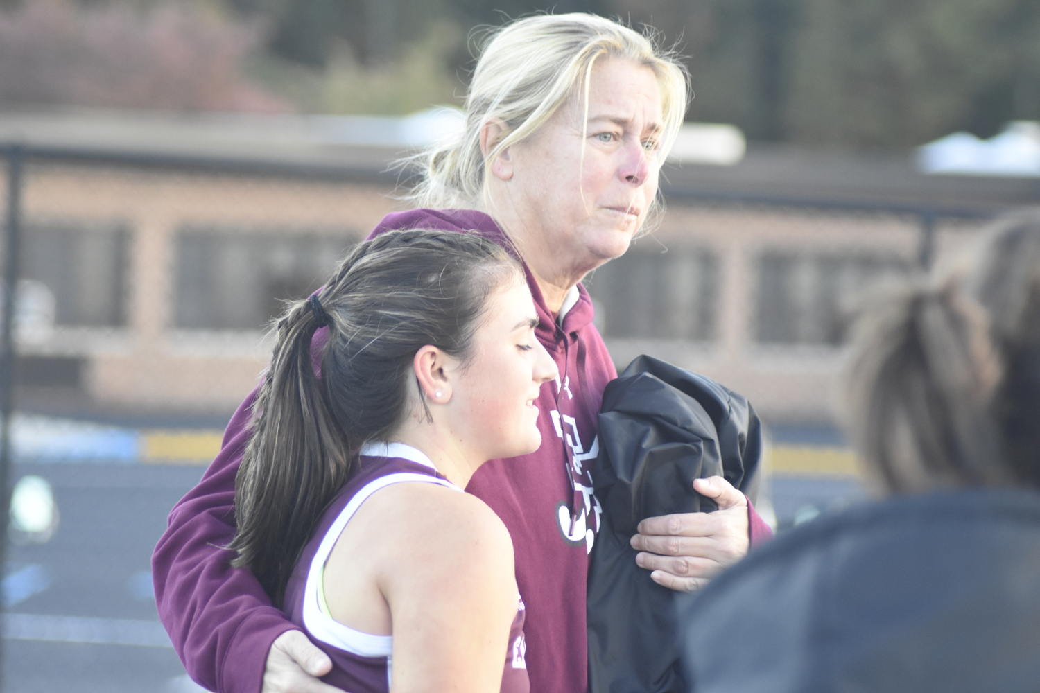 East Hampton head coach Danielle Schuster consoles one of her players after Tuesday's loss.   DREW BUDD