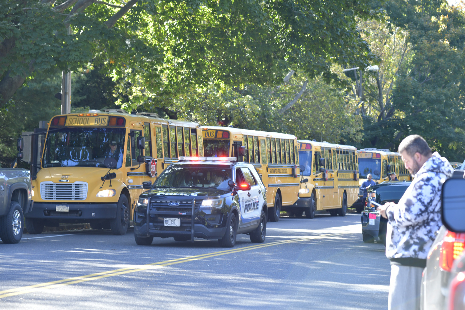 A line of buses wait to transport children  after a bomb threat was sent to a  Southampton School administrator.  DANA SHAW