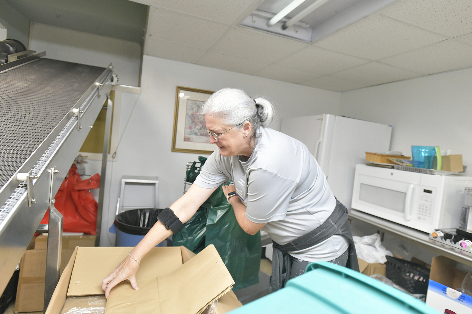 Heart of the Hamptons volunteer Diane Karlin puts together bags to be packed with food on Tuesday morning.  DANA SHAW
