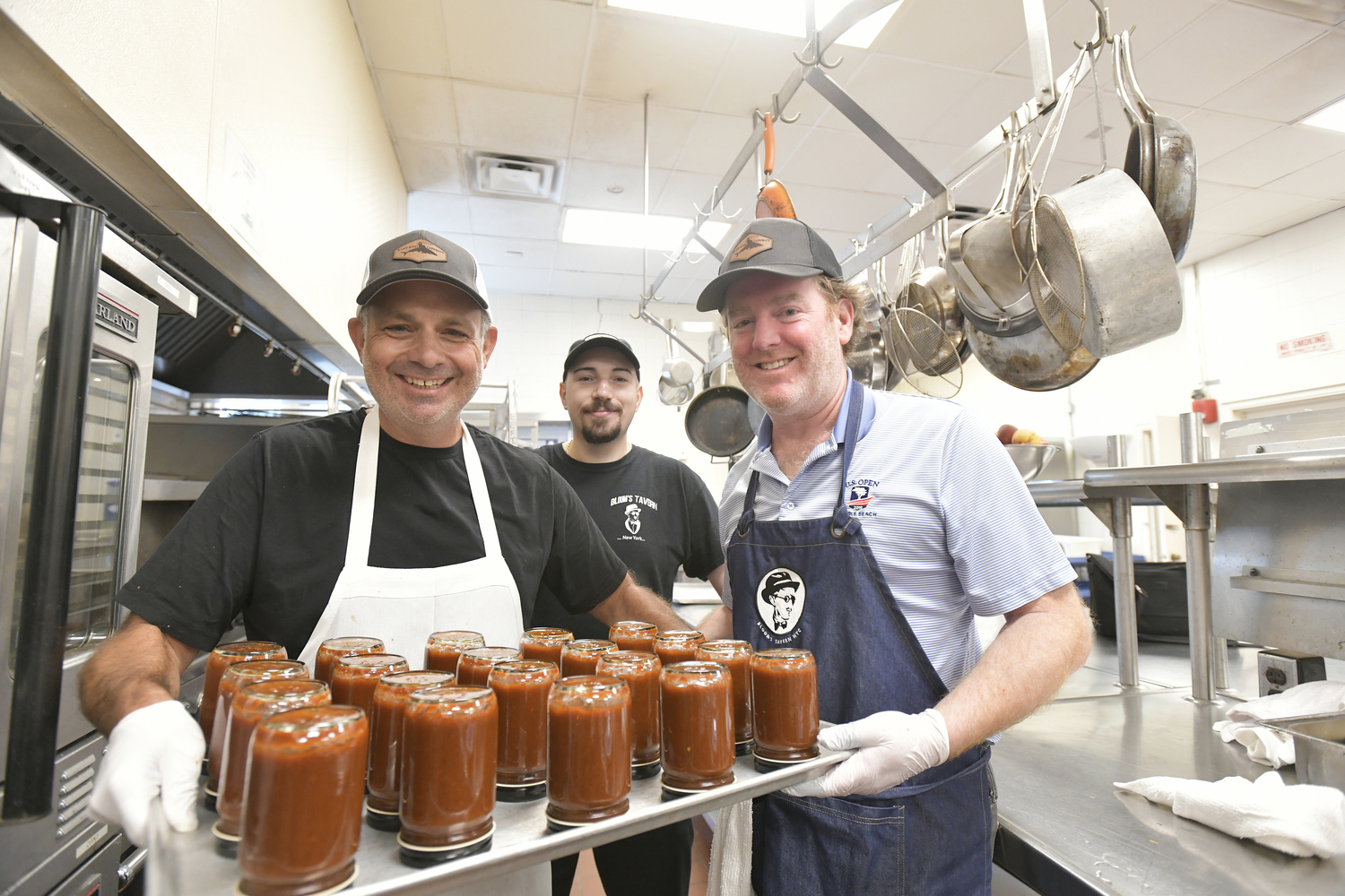 Jason Wagenheim, Matthew Dodd and Joe Machado with the bottled sauce.  DANA SHAW