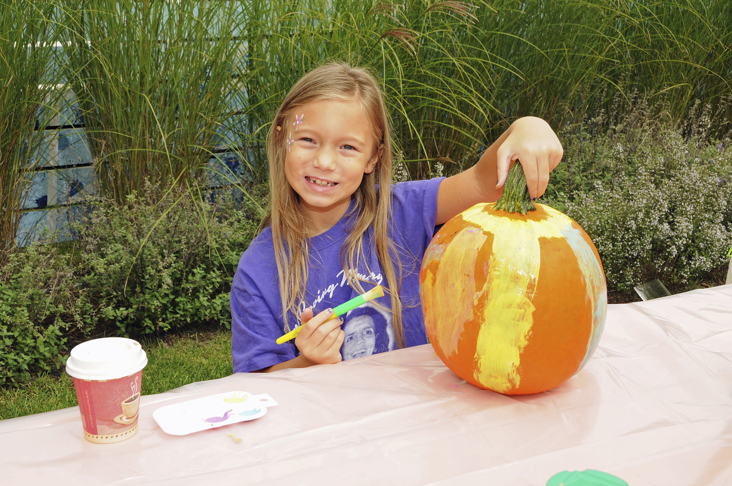 Kadence Podlas paints a pumpkin at the Fall Festival at The Clubhouse in East Hampton on Sunday.   RICHARD LEWIN