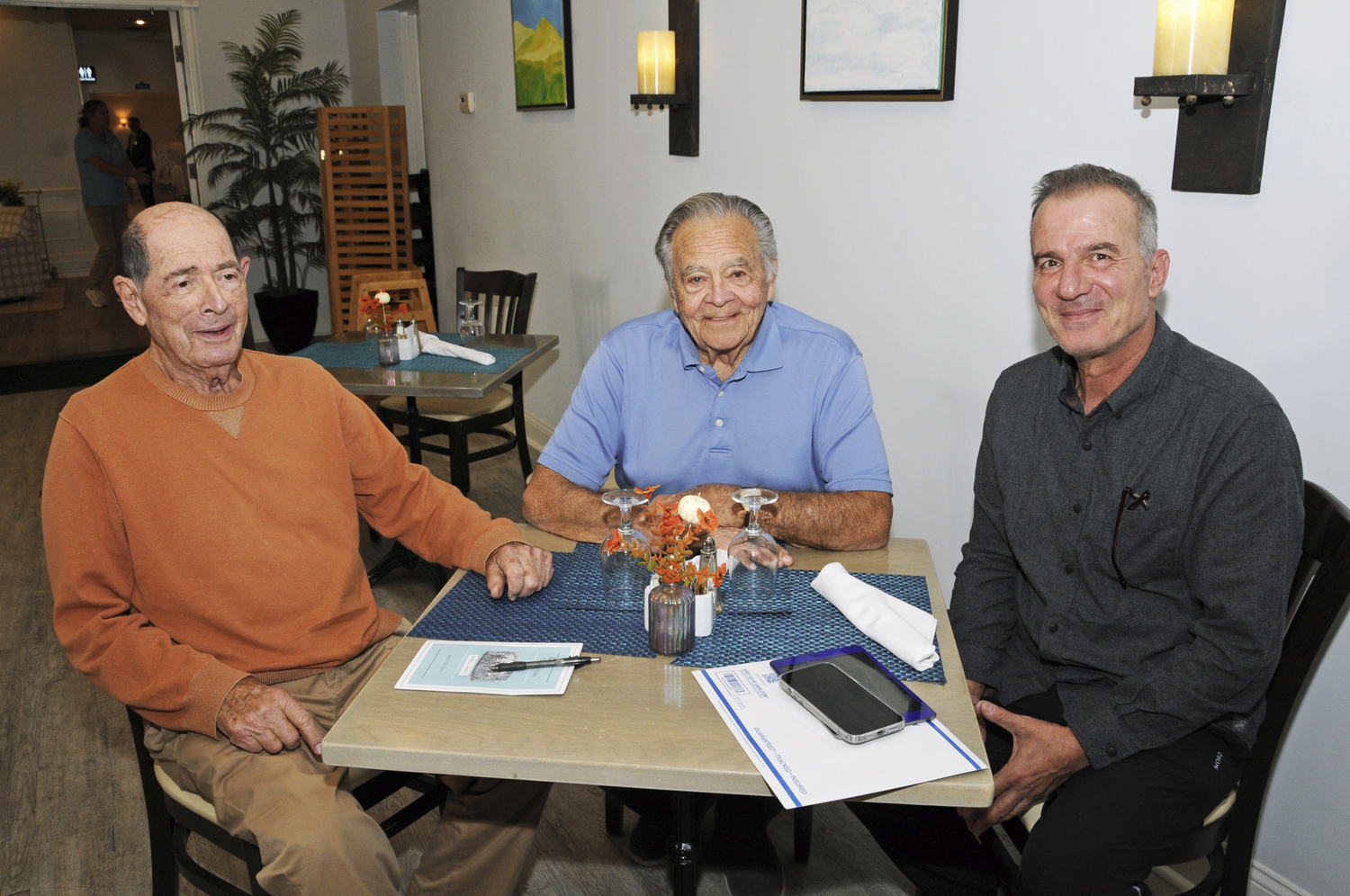 Former East Hampton Mayor Paul Rickenbach's Tuesday Club met for lunch at the Southampton Inn recently. Guest speaker and Renaissance man, poet, musician, painter of houses and on canvas, and LTV host Haim Mizrahi told his life story to the members. Pictured, Howard Chwatsky and Paul Rickenbach with Haim Mizrahi.  RICHARD LEWIN