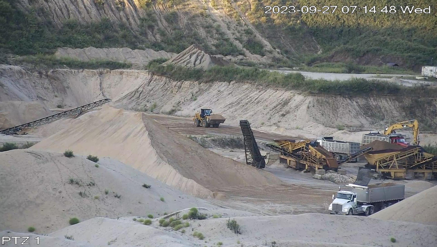 Photographs from a neighboring property show mining activity continuing at the Sand Land mine in Noyac after court orders requiring it to stop.