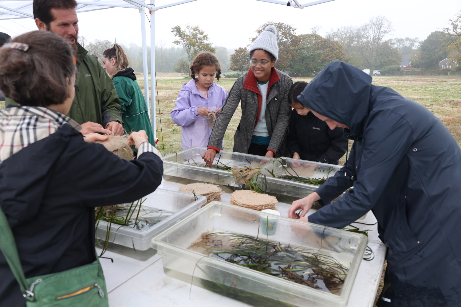 On Saturday, October 21, members of the Sag Harbor community - including Sag Harbor Mayor Tom Gardella (center) - gathered at Havens Beach for a Marine Meadows workshop with the Cornell Cooperative Extension of Suffolk County. Participants weaved adult eelgrass shoots into burlap planting units that the marine dive team will plant at restoration sites to improve water quality and coastal resiliency in the area. COURTESY PHOTOS