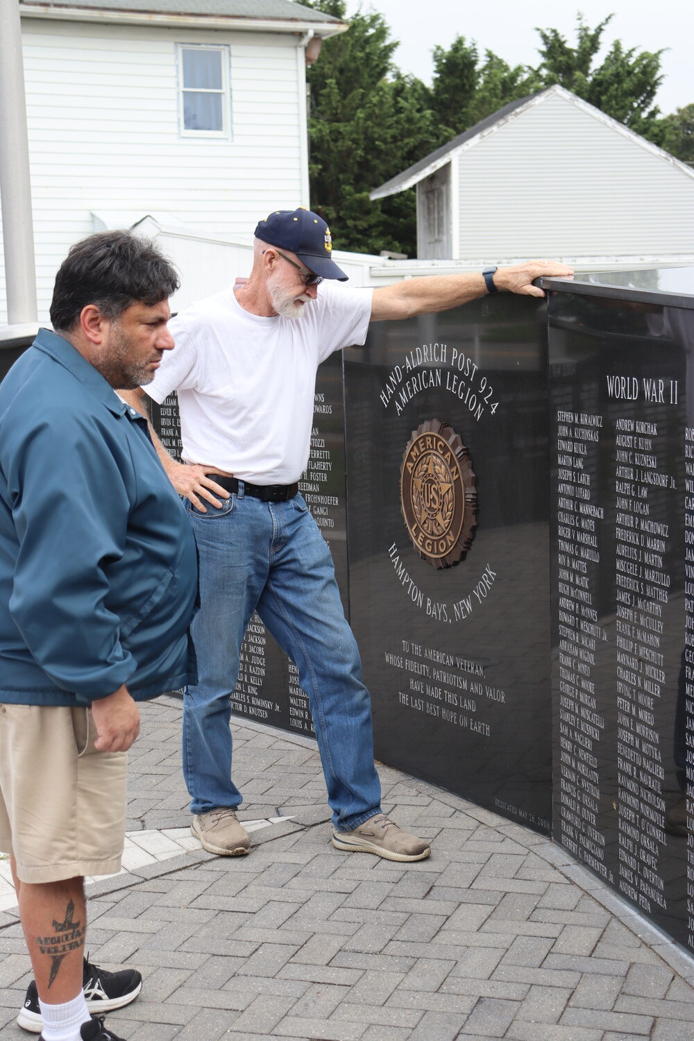 Past Commander Richie Steiber, right, and American Legion Finance Officer David Agtsteribbe at the Wall of Remembrance at the Hampton Bays American Legion Hand Aldrich Post 924 on Ponquogue Avenue. CAILIN RILEY