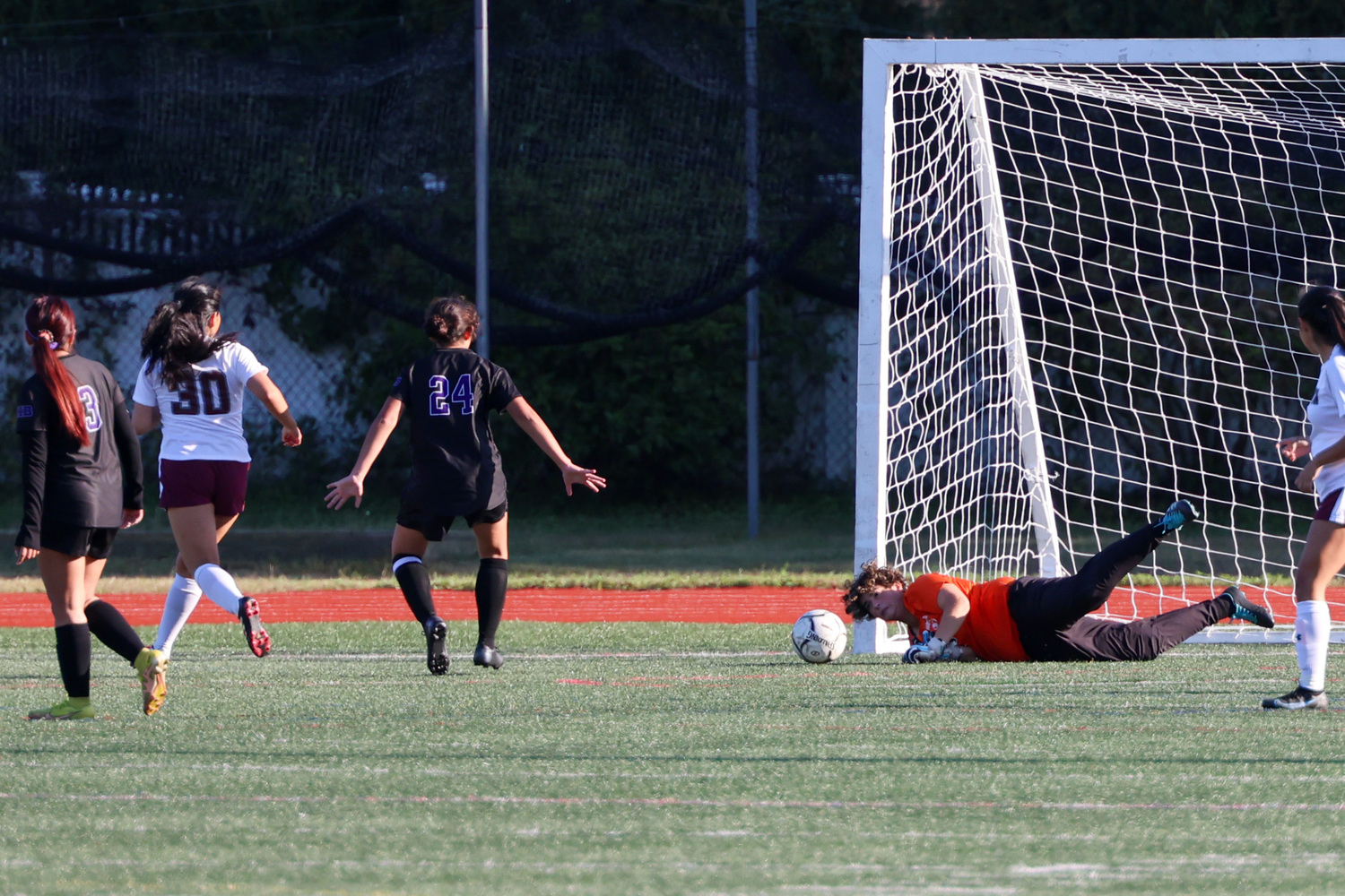 Hampton Bays senior goalie Jordyn Heaney makes an initial stop on a shot but East Hampton senior Rihanna Pinos knocked in the rebound for the first goal of the game.   MICHAEL O'CONNOR