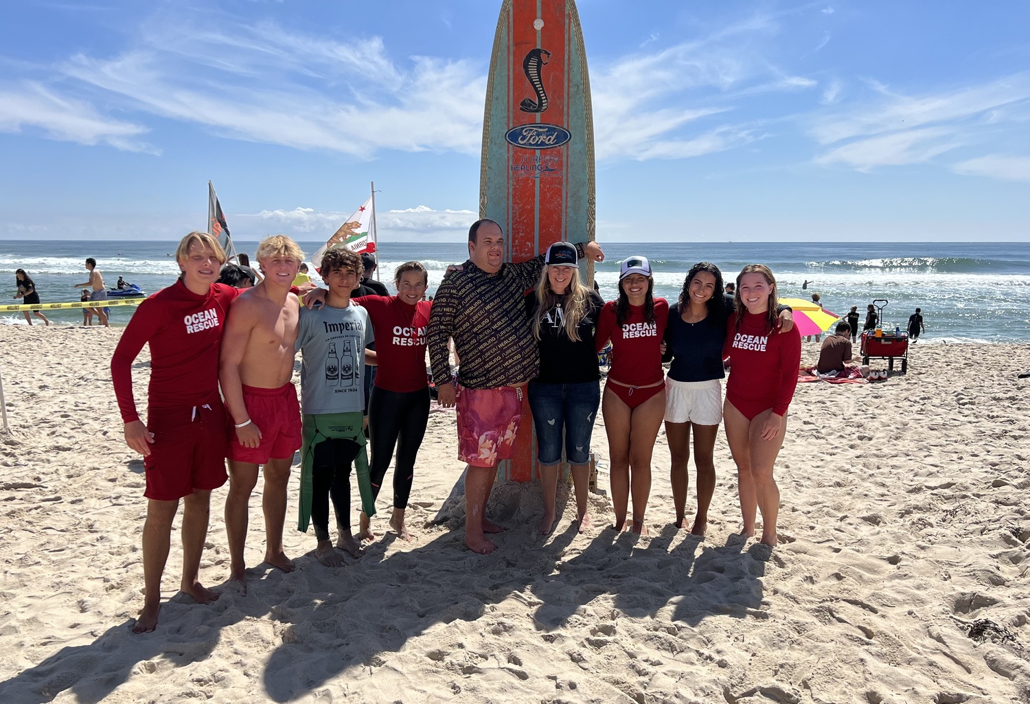 Southampton High School Outing Club members recently volunteered at a Surfers Healing event at Ponquogue Beach in Hampton Bays. Surfers Healing aims to enrich the lives of people with autism by exposing them to the unique experience of surfing. Students and their advisor Maria Theresa Abbadessa, with the inspiration for Surfers Healing, Isaiah Paskowitz, and his mother, Danielle Paskowitz. COURTESY SOUTHAMPTON SCHOOL DISTRICT