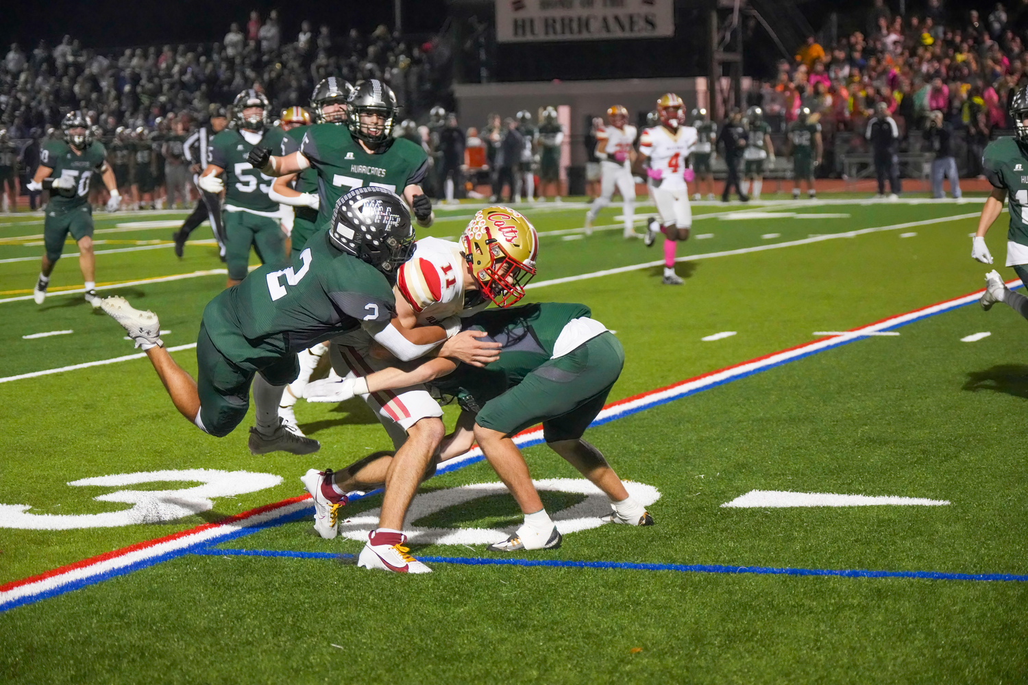 Gianni Amodemo and another Hurricane team up to take down Hills West quarterback Joseph Filardi.   RON ESPOSITO